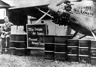 Aviator Capt. Charles Lindbergh, 110th Observation Squadron, 35th Division, Missouri National Guard (now 131st Bomb Wing, Missouri Air National Guard) poses beside the "Spirit of Saint Louis" at Robertson Field with a representation of how much fuel was required to complete his historic 33 1/2 solo flight from New York to Paris in the "Spirit of Saint Louis" on May 21, 1927.